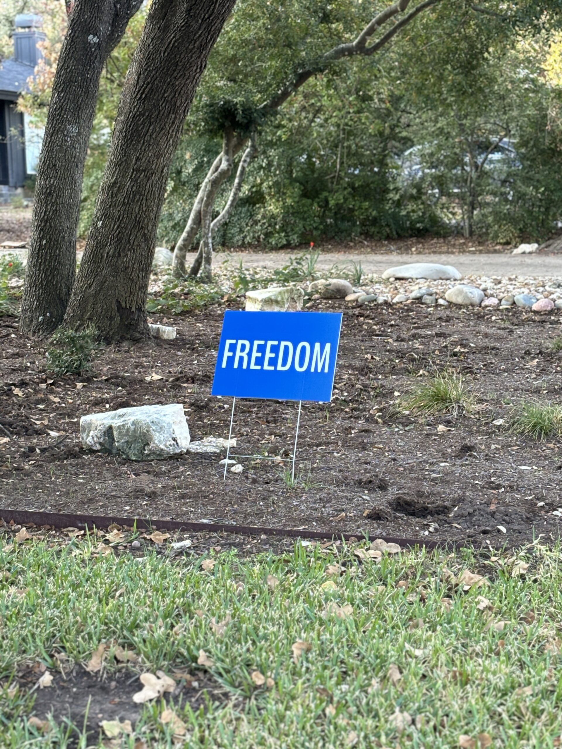 Freedom yard sign captured in the hills of Northwest Austin on Nature Walk on the Fuck Fear podcast with Catenya McHenry